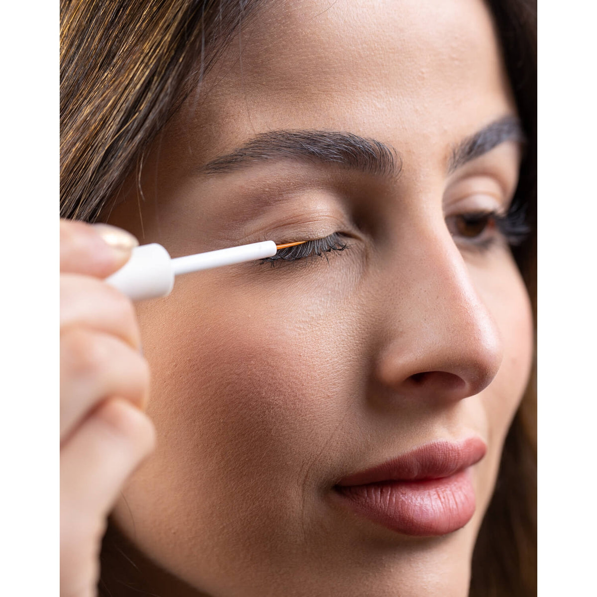 Woman applying Ramsha eyelash serum at the root of her upper lashes